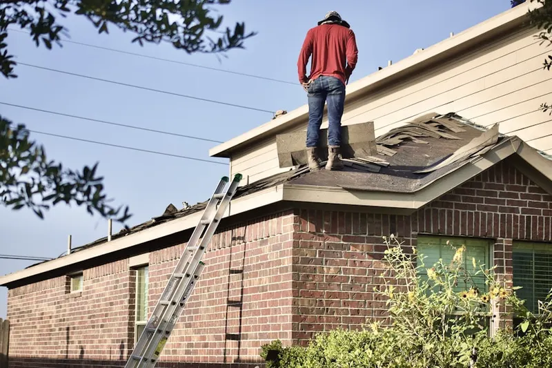 Professional roofer working on a residential roof in Lenoir